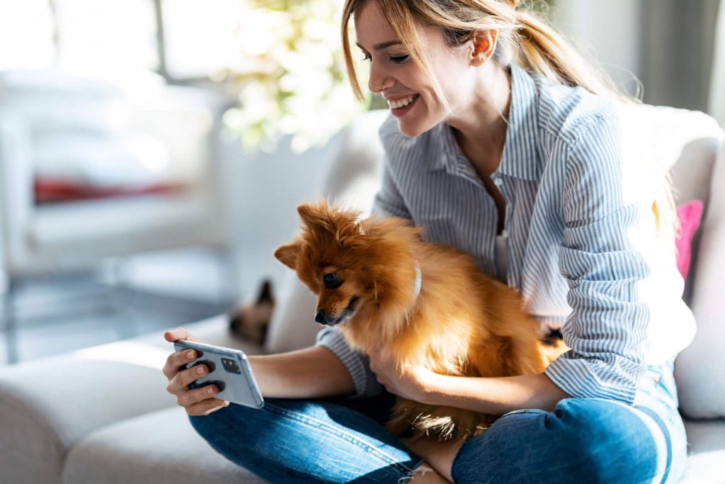 Frau mit Hund am Handy